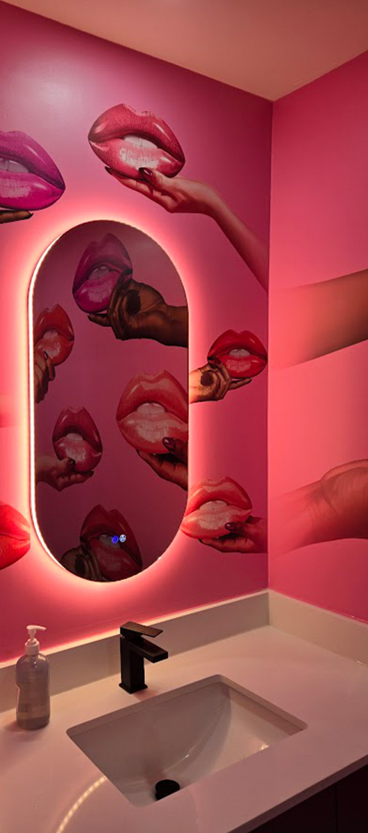 Custom pink wall mural with lips design in modern commercial bathroom
