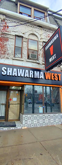 Shawarma Restaurant LED Channel Letters LED channel letter storefront sign with illuminated white and orange lettering installed on restaurant facade