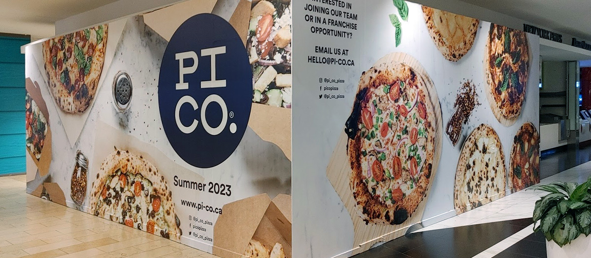 Large-format temporary construction wall wrap with pizza branding in Toronto