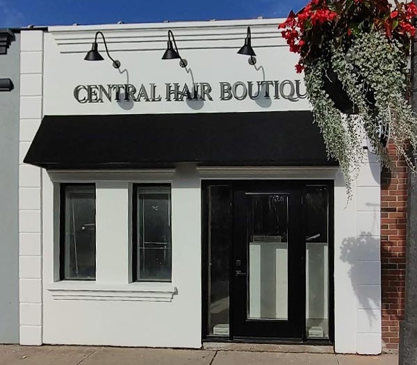 Black custom storefront awning installed above salon entrance